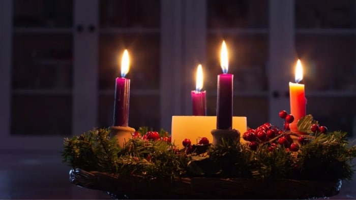 Horiaci adventný veniec s piatimi sviečkami.