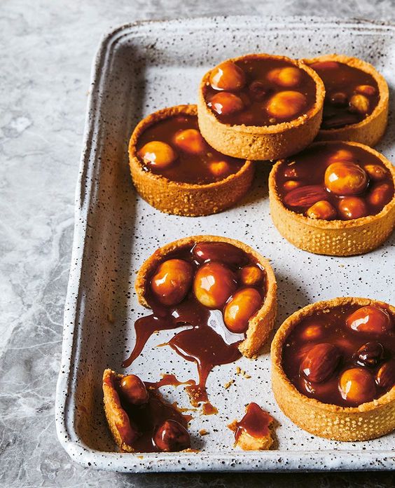 Malé tartaletky naplnené krémom a slaným karamelom s makadamovými orechmi.