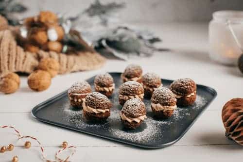 Orechy plnené krémom z vanilkového pudingu, mliečnej čokolády a orechovej pasty na plechu.